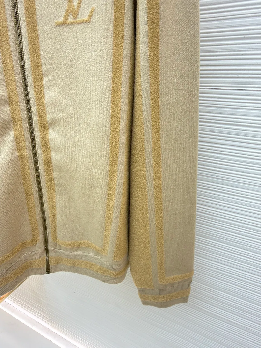 LOUIS VUITTON two-color splicing intarsia zipper jacket ●Original version: purchased and developed at 20700 ●Item number: 1681968-C15 ●Fabric: nylon fabric ●Technology: intarsia production ●Color: khaki ●Version: fitted version ●Weight: about 1020 grams ●Size: XS-S-M-L ●Description: Made of 43% nylon, 32% cotton and 25% viscose blended fabric, which has both comfort and stiffness. The designer used two-tone intarsia technology to allow contrasting color strips to run through the sleeves and body, forming a smooth visual extension. Different areas create subtle three-dimensional texture effects by changing knitting density and stitching methods. The chest is decorated with a delicate intarsia LV logo, and the Vuitton word is presented in elegant font on the back, showing brand recognition in every detail. The collar, cuffs and hem made of rib knitting technology not only enhance the stability of the silhouette, but also echo the overall design language. The front placket features a smooth zipper closure and practical slip pockets on both sides for added functionality. The entire piece perfectly interprets the exquisite aesthetics of sports and leisure style through the ingenious combination of fabric texture and craftsmanship details. The overall wiring is straight and delicate, the fabric is comfortable and soft, and the color is consistent without color difference. It can be matched with the same style to create a fashionable look and control various occasions. Customized accessories, complete with three standards, same style for men and women!